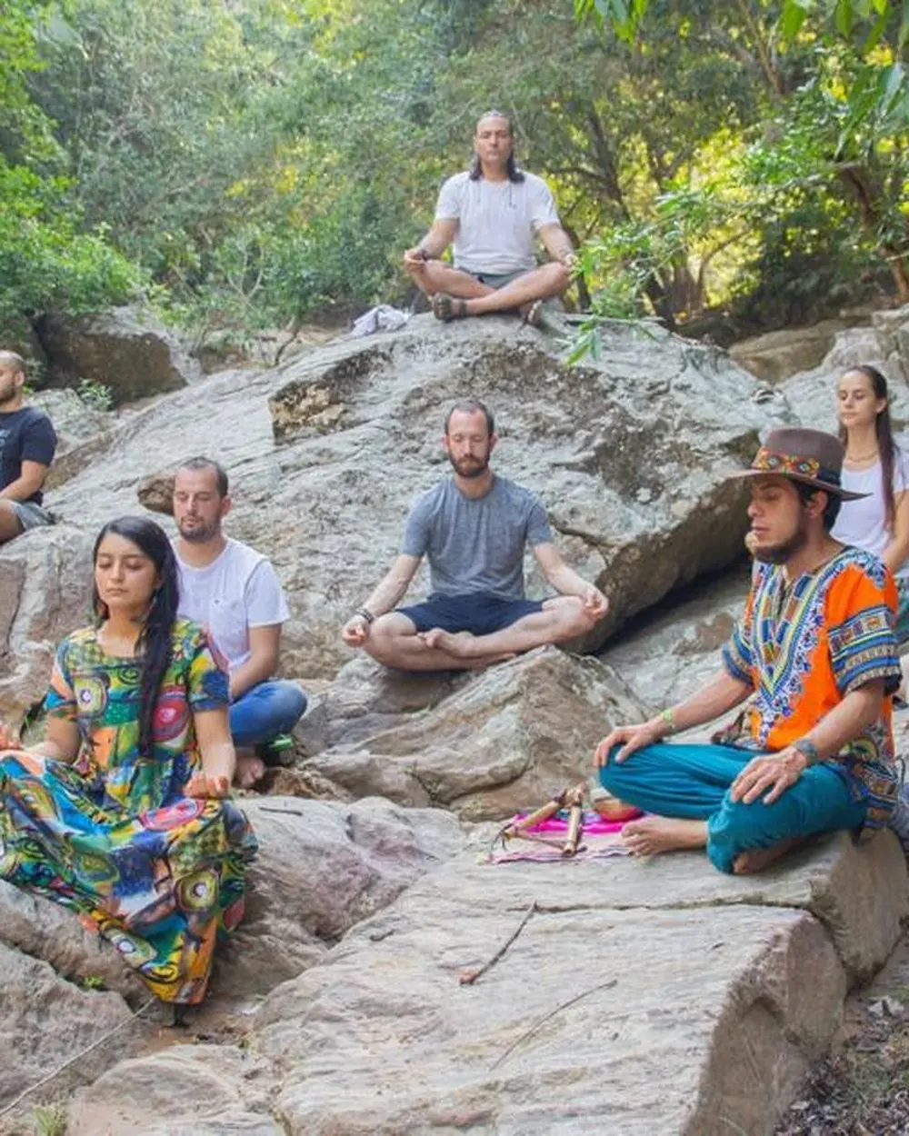 Grupo en meditación sobre las piedras del río