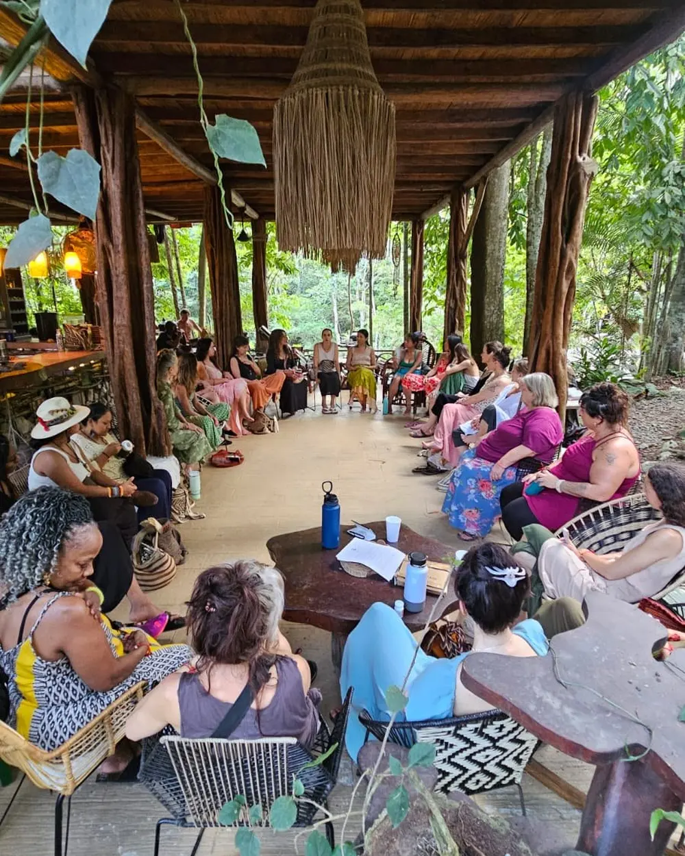Grupo reunido en una mesa larga bajo techo